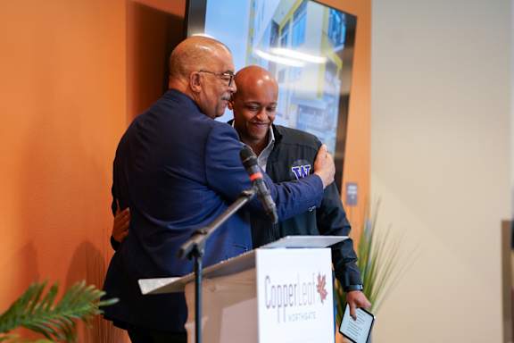 Two men hug at a Copper.io event.