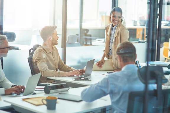 A group of people are working together in a brightly lit office.