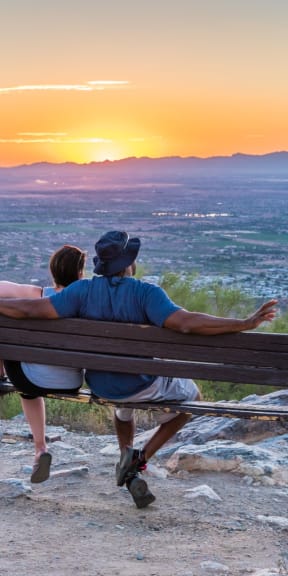 Couple Sitting on Bench Together Admiring Sunset and View