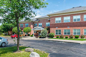A red brick building with a tree in front of it.