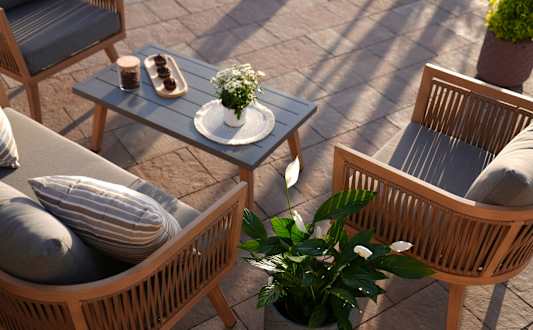 A patio with a table, chairs, and potted plants.