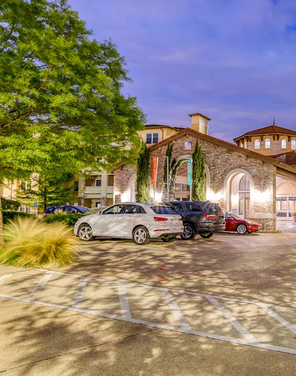 A parking lot with cars and a building in the background.