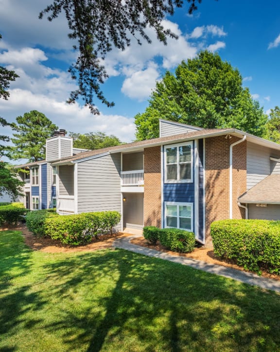 a house with a lawn and trees in front of it at Arbor Ridge, Greensboro