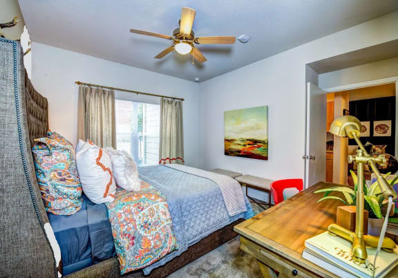 a bedroom with a bed and a ceiling fan at Villa Espada Apartments, San Antonio, Texas