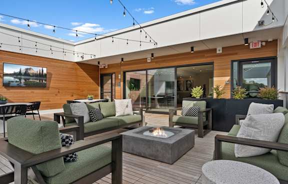 A patio with a fire pit and seating area.