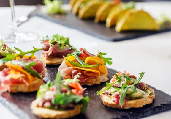 a tray of sandwiches on a table with fruit