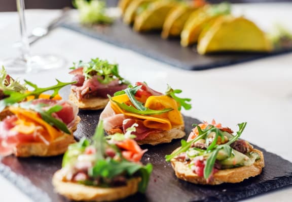 a tray of sandwiches on a table with fruit