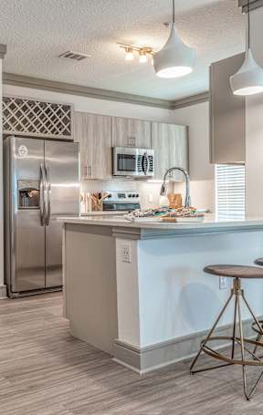 an open kitchen with a granite counter top and stools
