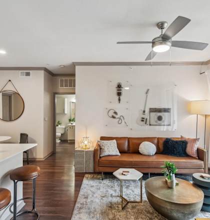 A modern living room with a brown leather couch and a wooden coffee table.