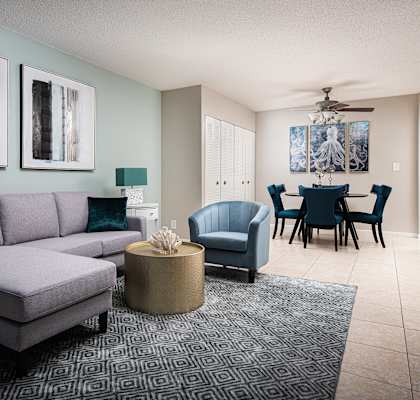 a living room with a couch and chairs and a dining room table  at Fairways of Inverrary, Lauderhill, Florida