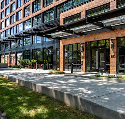 A modern building with a glass facade and a brick exterior.