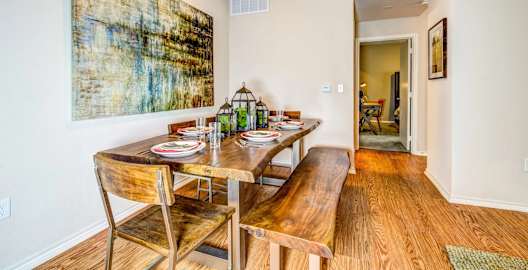 a dining room with a table and chairs and a painting on the wall at Villa Espada Apartments, San Antonio, Texas
