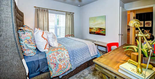 a bedroom with a bed and a ceiling fan at Villa Espada Apartments, San Antonio, Texas