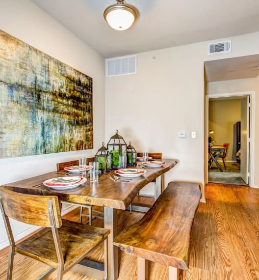 a dining room with a table and chairs and a painting on the wall at Villa Espada Apartments, San Antonio, Texas