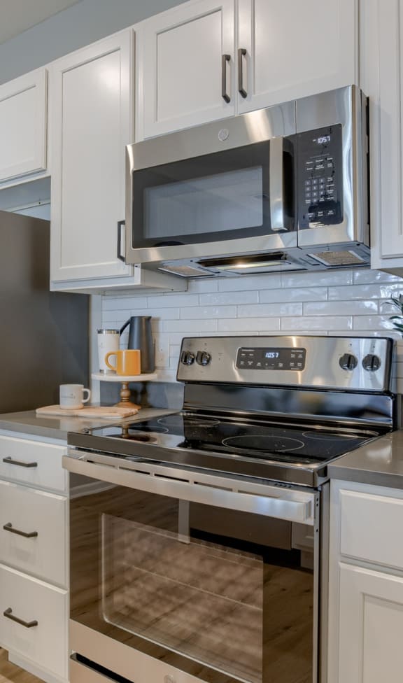 a kitchen with white cabinets and stainless steel appliances