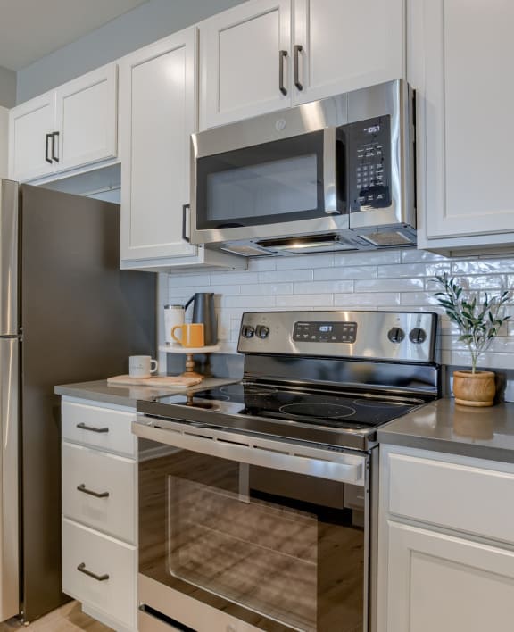 a kitchen with white cabinets and stainless steel appliances