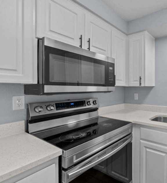 A modern kitchen with a black microwave above the stove.