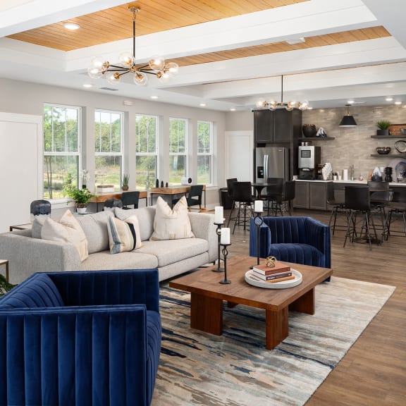 a living room with blue couches and chairs and a table