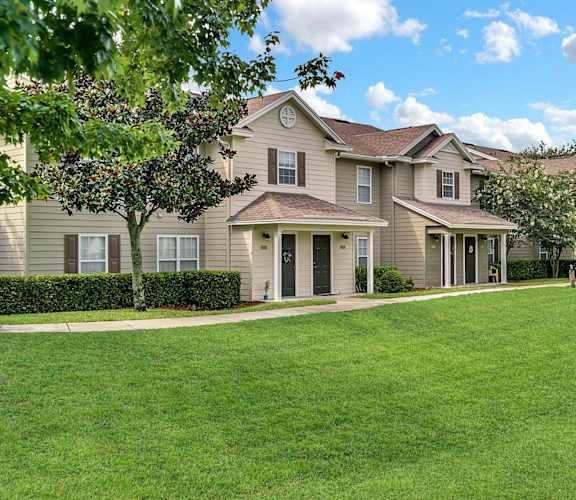 a large grassy area with a large house in the background