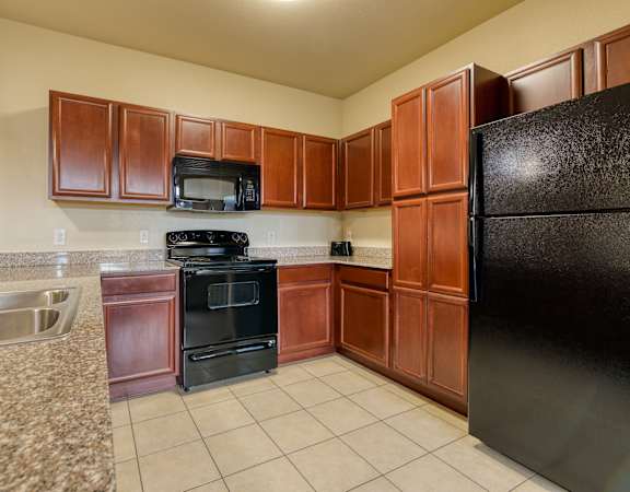 a kitchen with wood cabinets and black appliances