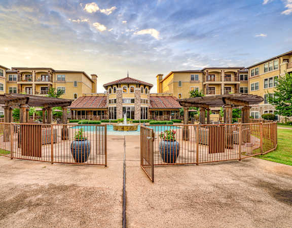 a mansion with a pool in the middle of a grassy area