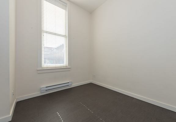 an empty room with a window and a radiator