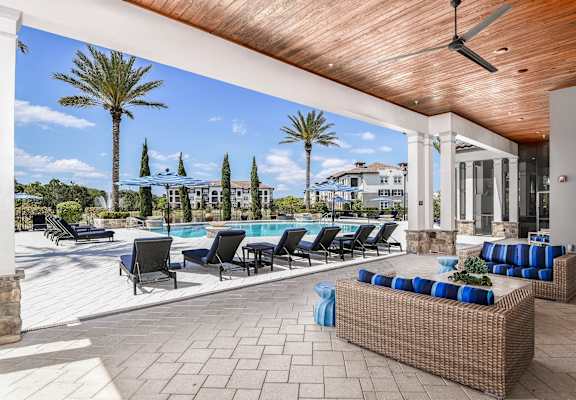 the pool area of a house with a pool and patio furniture
