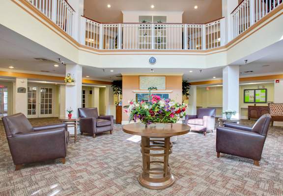 a large lobby with a table with flowers in the middle of it