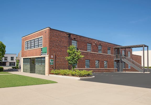 A brick building with a green sign that says "PARKING" in front of it.