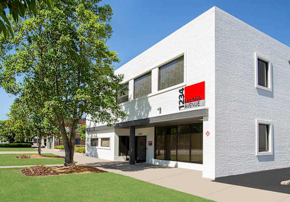 A white building with a red sign that says Avenue.