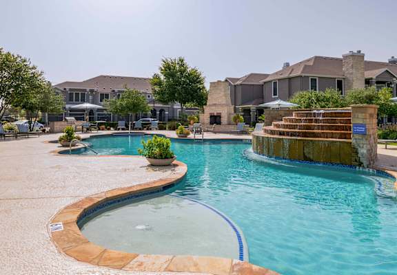 a large swimming pool with a house in the background at Orion Prosper Lakes in Prosper, TX