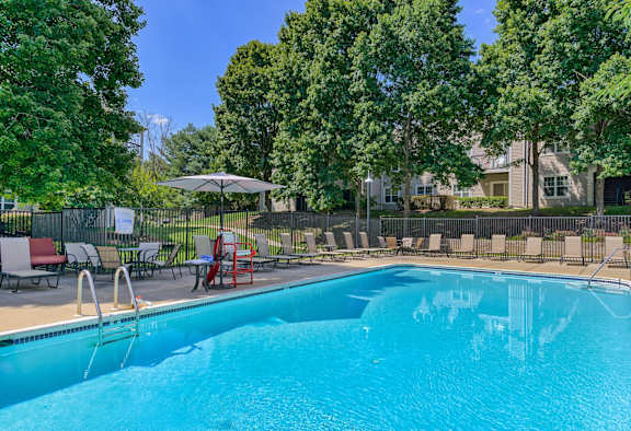 a swimming pool with chairs and umbrellas next to a pool