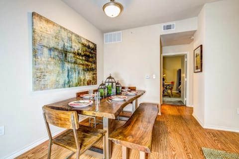 a dining room with a table and chairs and a painting on the wall at Villa Espada Apartments, San Antonio, Texas