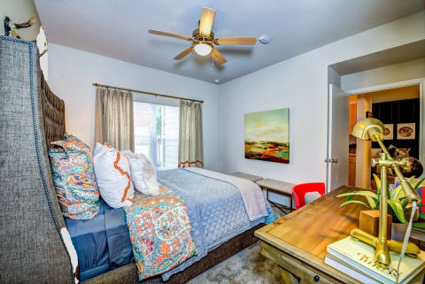 a bedroom with a bed and a ceiling fan at Villa Espada Apartments, San Antonio, Texas