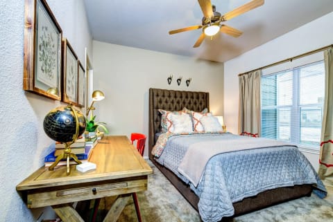 a bedroom with a bed and a ceiling fan at Villa Espada Apartments, San Antonio, Texas