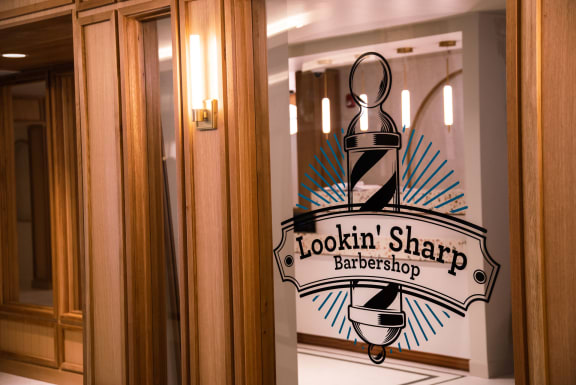 a sign on a door that says lookin sharp barbershop