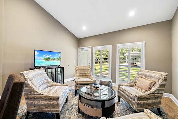 A modern kitchen with a large island and a painting on the wall.