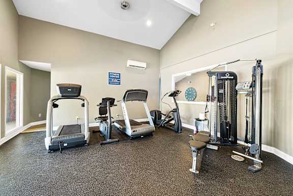 A spacious home gym with a variety of equipment including treadmills, weights, and exercise machines.
