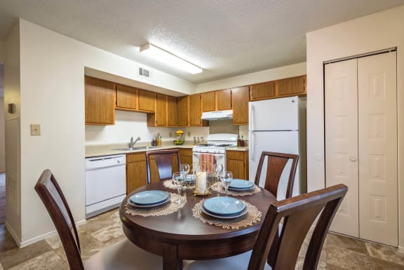 a dining room table with a kitchen in the background at Olive Branch Townhomes, Batavia