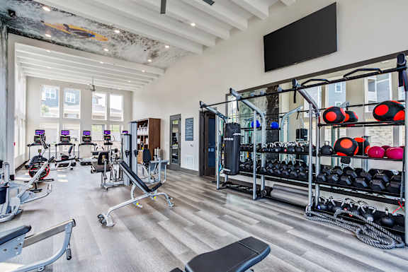 A gym with a variety of equipment including weights and machines.