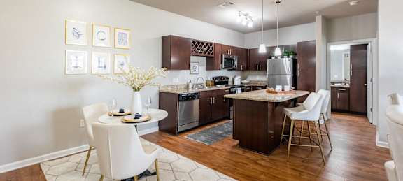 A kitchen with a table and chairs in the middle of the room.