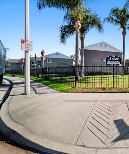 A street corner with a "No Parking" sign and a building in the background.