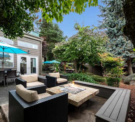 A patio with a fire pit and seating area.