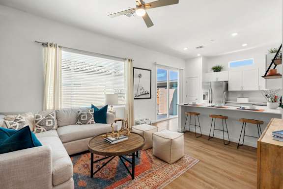 A living room with a couch, a coffee table, and a ceiling fan.