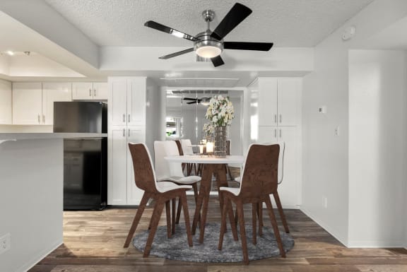 a dining room with a table and chairs and a ceiling fan