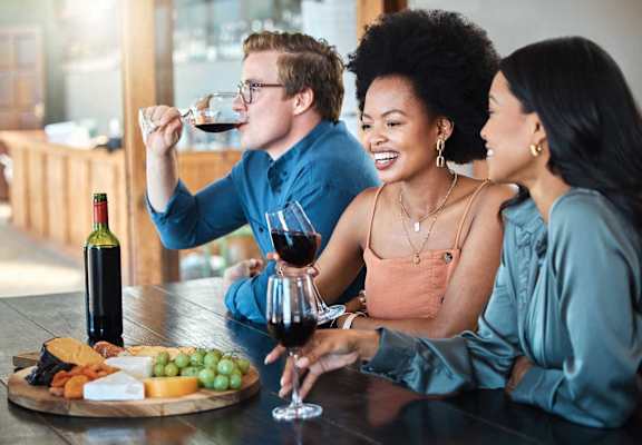 Three people enjoying a glass of wine together.
