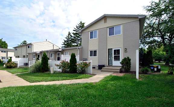 A row of houses with a white picket fence.