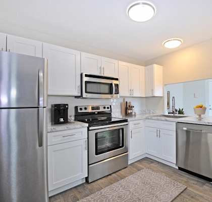 A kitchen with white cabinets and stainless steel appliances.