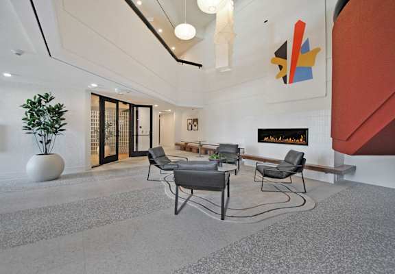 a lobby with a table and chairs in front of a fireplace