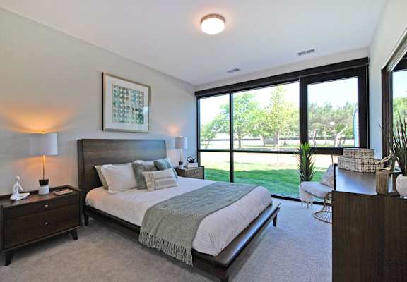 a bedroom with a bed and a large window